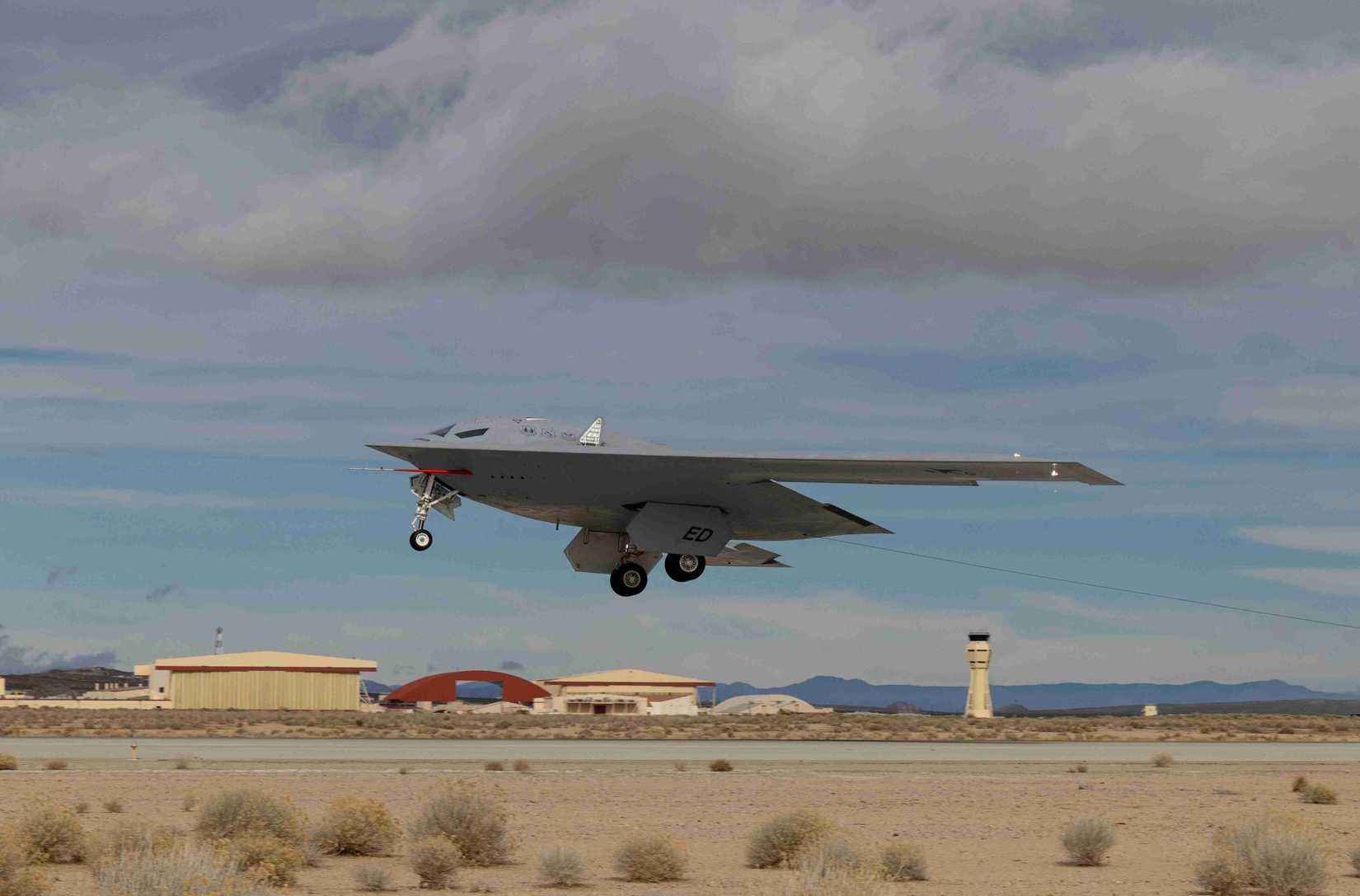 A B-21 Raider conducts flight tests, which includes ground testing, taxiing, and flying operations, at Edwards Air Force Base