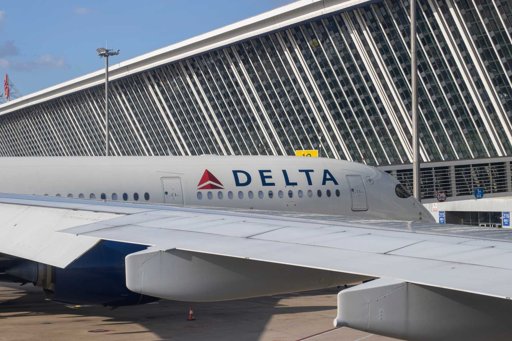 A Delta Air Lines aircraft is seen parked at a terminal gate through an airplane window in Shanghai's Pudong International Airport
