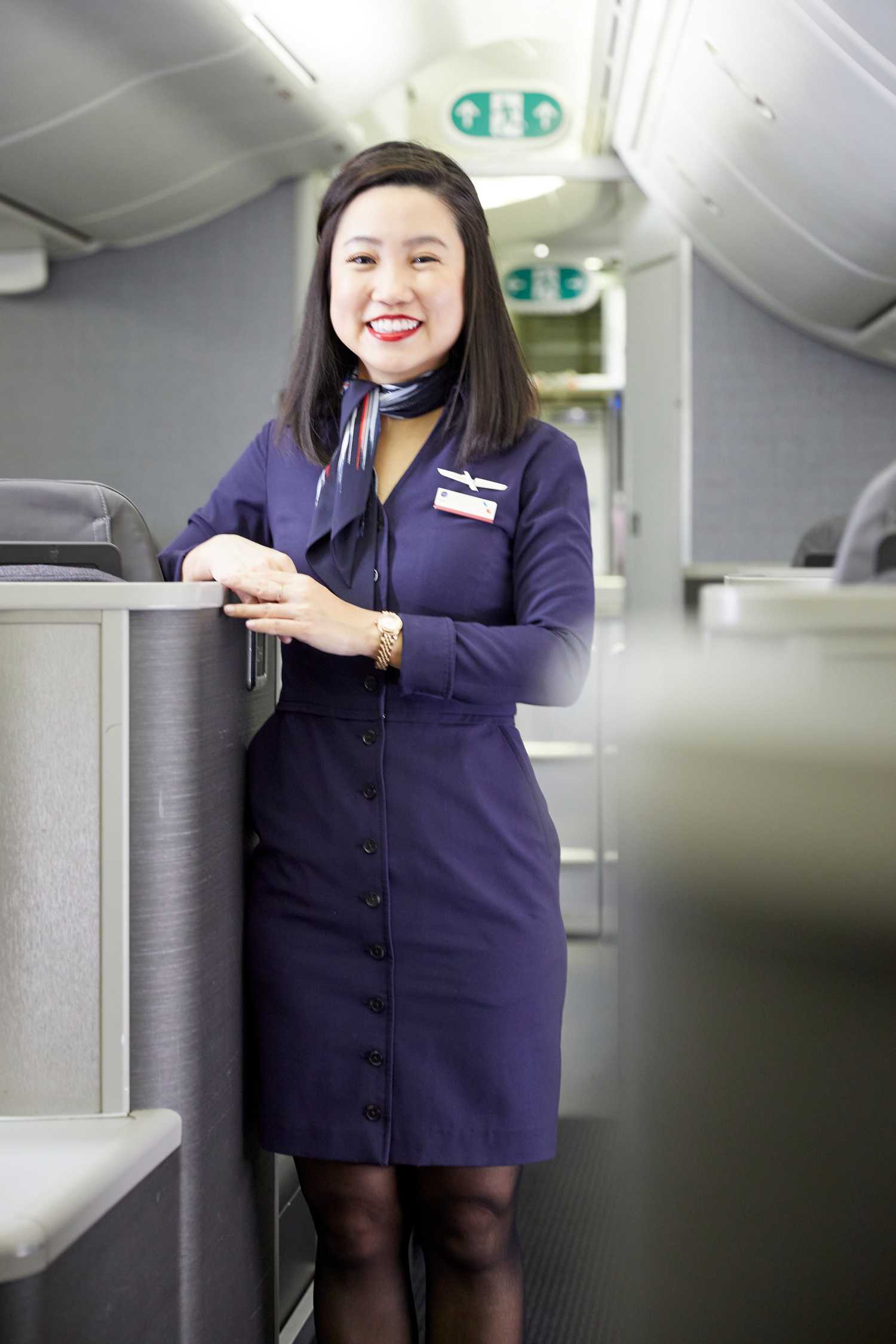 American Airlines flight attendant standing in aisle