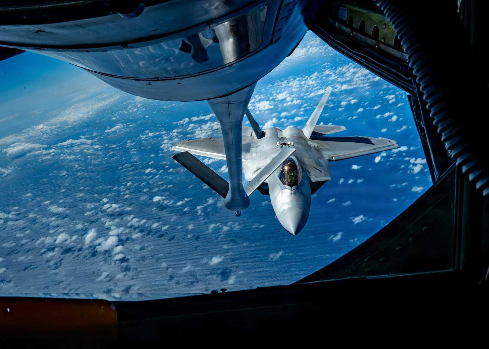 Air Force F-22 Raptor assigned to the 27th Expeditionary Fighter Squadron, deployed to Kadena Air Base, Japan, approaches a KC-135 Stratotanker