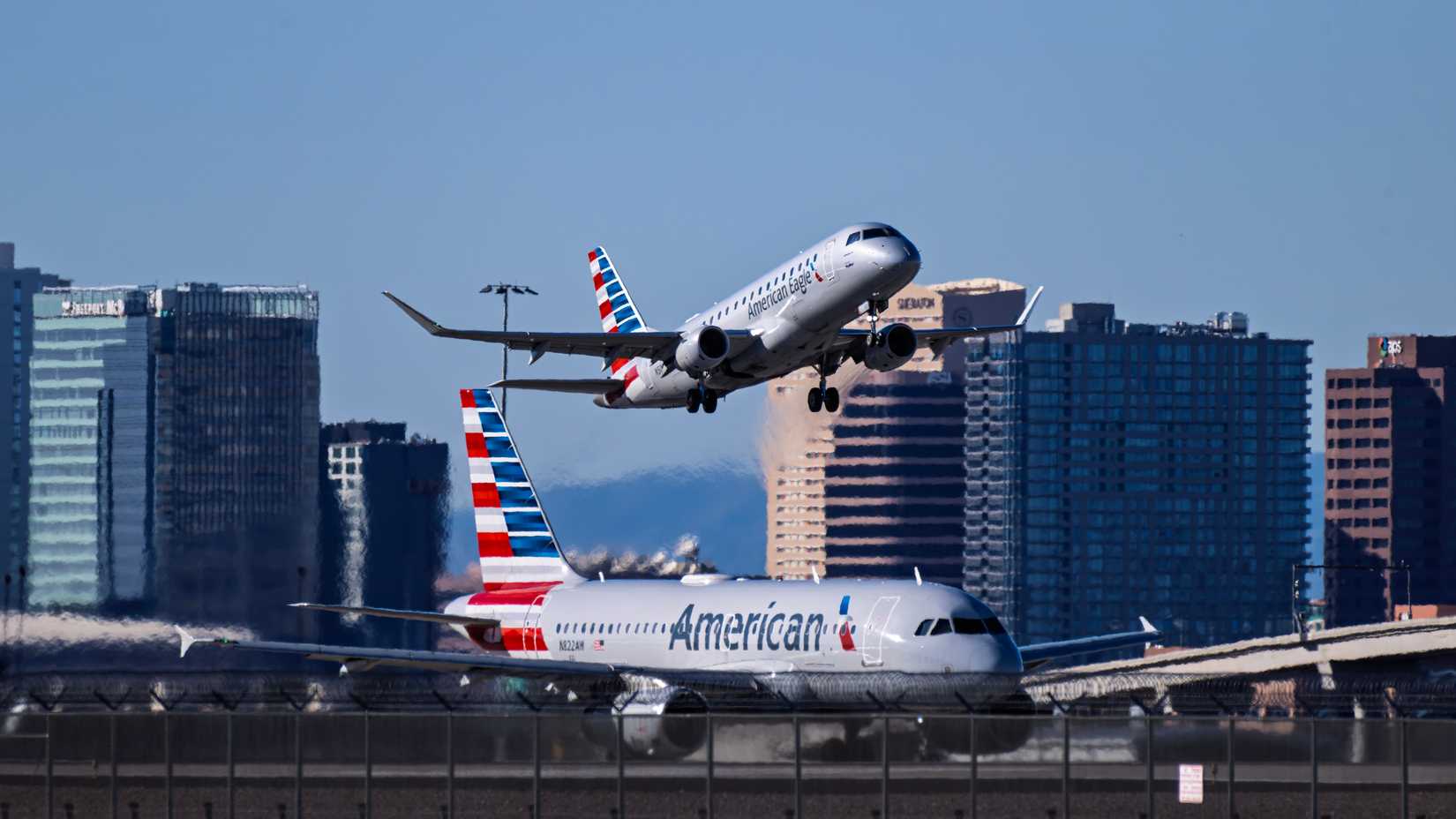 American Eagle E175 takeoff with cityscape