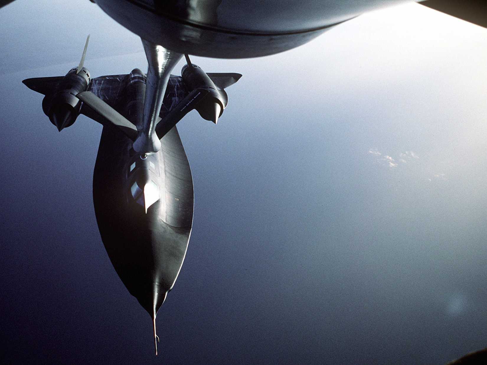 An air-to-air front view of an SR-71 Blackbird aircraft being refueled by another aircraft during refueling operations