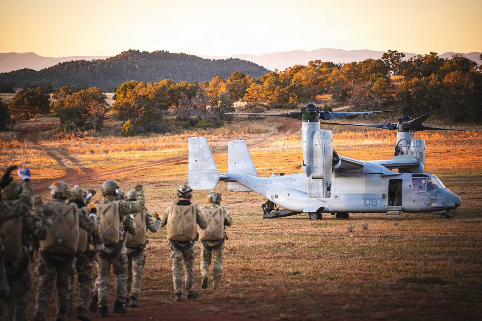 Army Green Berets with the 10th Special Forces Group (Airborne) walk to a U.S. Marine Corps V-22 Osprey