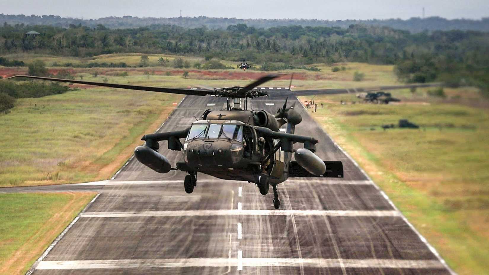  Army UH-60 Black Hawk helicopters assigned to Task Force Saber, 25th Combat Aviation Brigade flies over the runway
