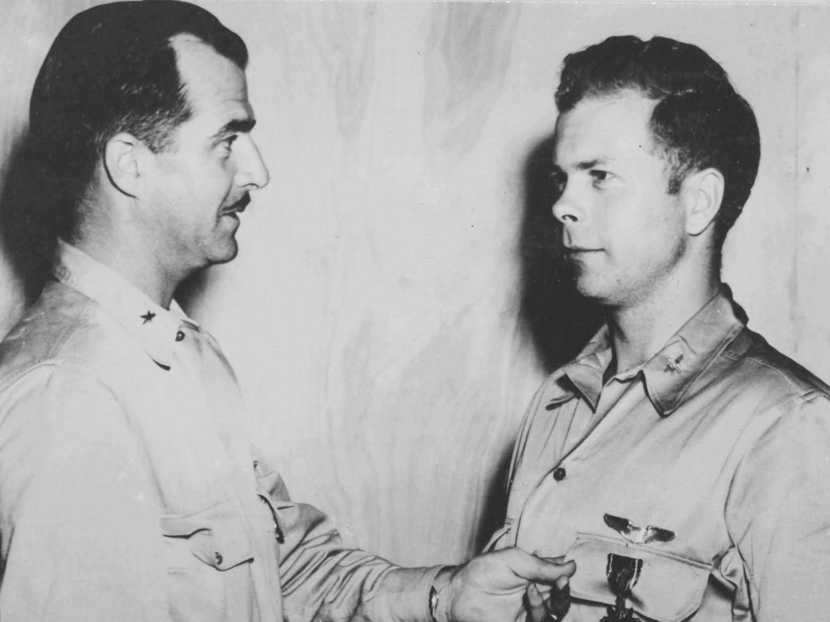 Capt. Richard I. Bong, 23, ranking Ace in the Southwest Pacific, is decorated with the Distinguished Service Cross by Brig. General Paul B. Wortsmith.