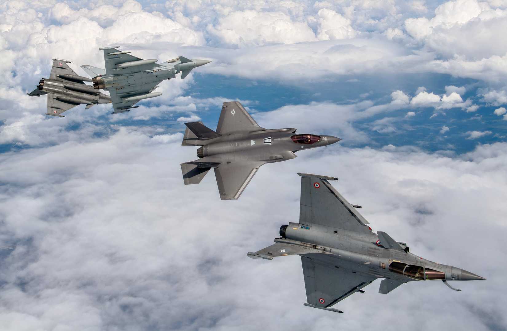 A photo showing an F-35 and three Eurofighter Typhoons engaging in drills above the clouds. 