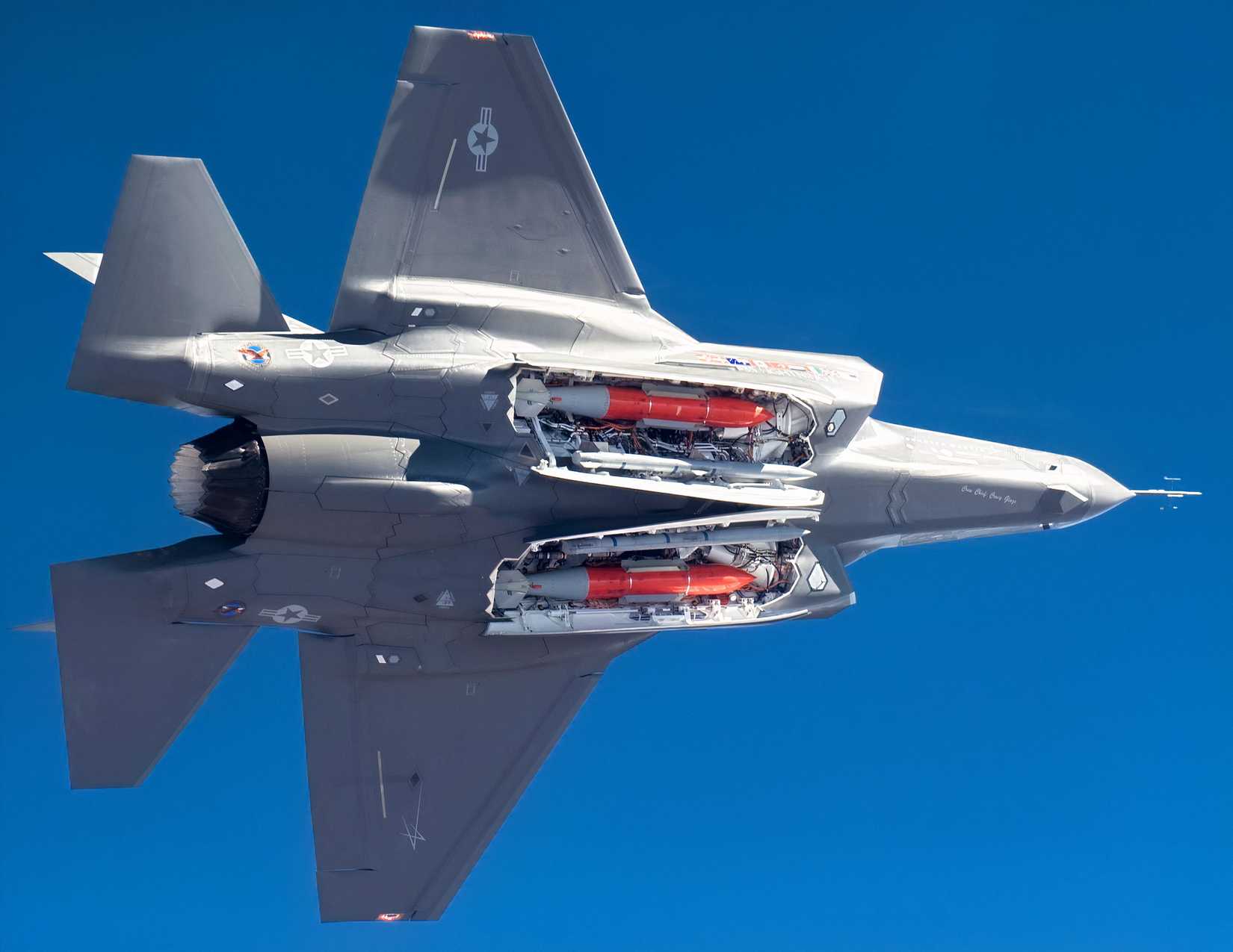 An F-35 with open weapon hatches displaying two B61-12 nuclear gravity bombs.