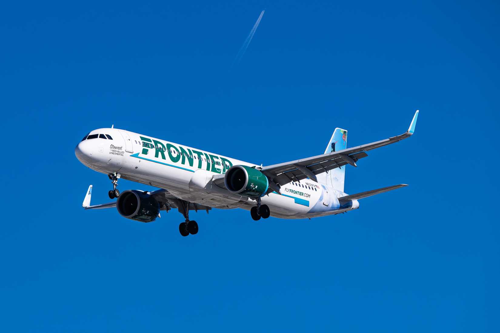 Frontier Aircraft flying across clear skies