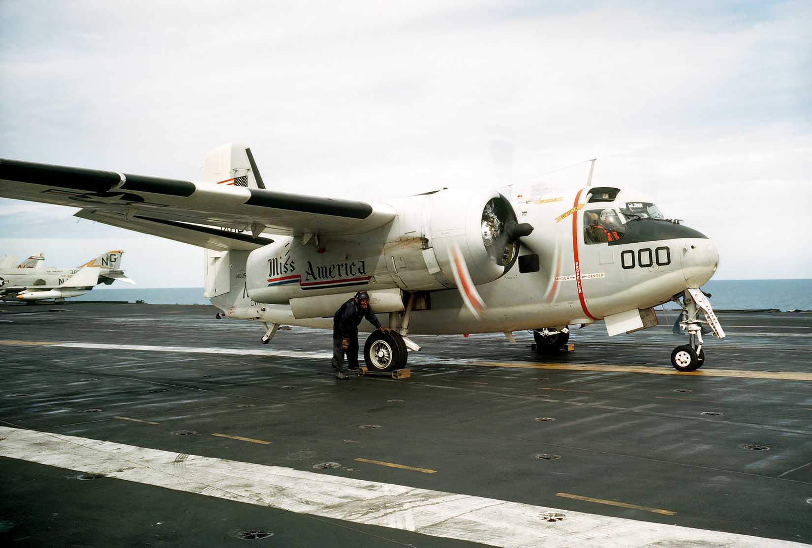 A photo of a Grumman C-1 Trader on the deck of a carrier preparing to takeoff.
