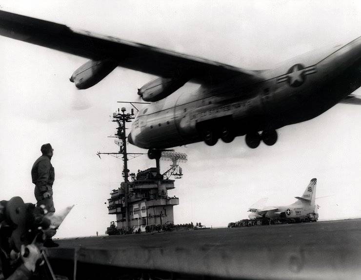 A black and white photo of a KC-130F landing on the USS Forrestal.