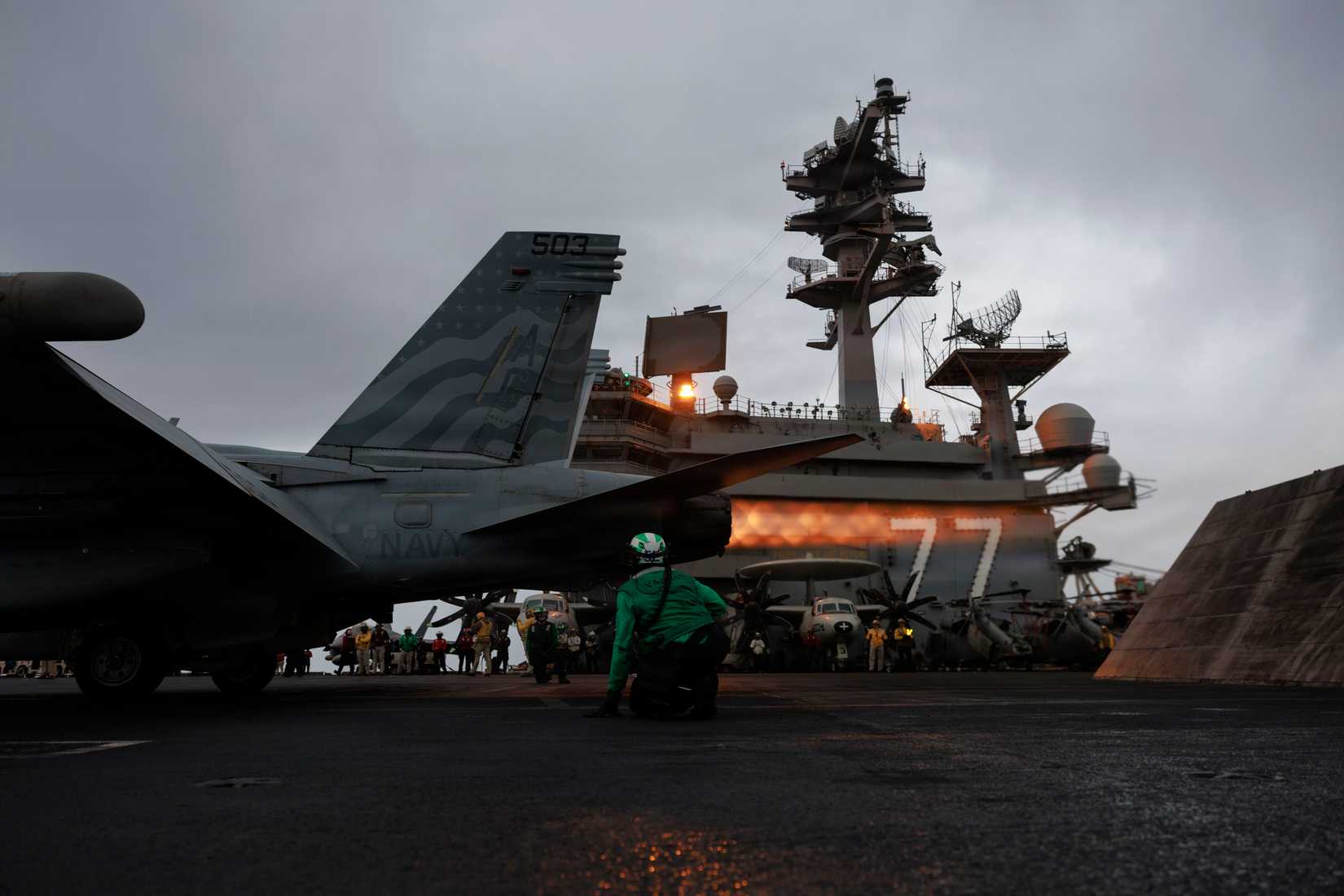 Sailor signals an EA-18G Growler, attached to Electronic Attack Squadron (VAQ) 140, on the flight deck of Nimitz-class aircraft carrier USS George H.W. Bush (CVN 77)
