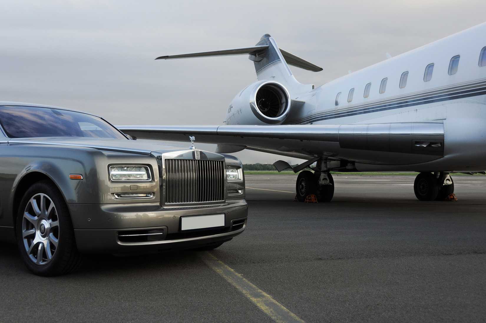 Private executive airplane with limousine Rolls Royce Phantom luxury car shown together at international Heathrow Airport. VIP service at the airport. Business class transfer.