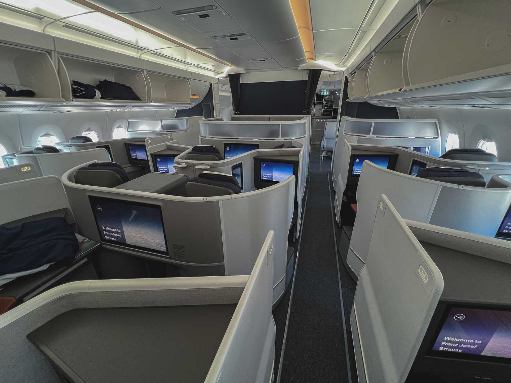New Lufthansa Allegris long-haul Business Class cabin with fully enclosed suites with doors, staggered lie-flat seating layout onboard Airbus A350 taken after landing at Munich Airport on 9 July 2024