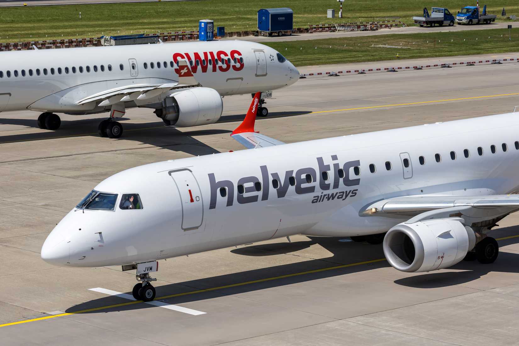 Zurich, Switzerland - June 17, 2025: Helvetic Airways Embraer 190 and Swiss Airbus A220-300 airplanes at Zurich airport in Switzerland.
