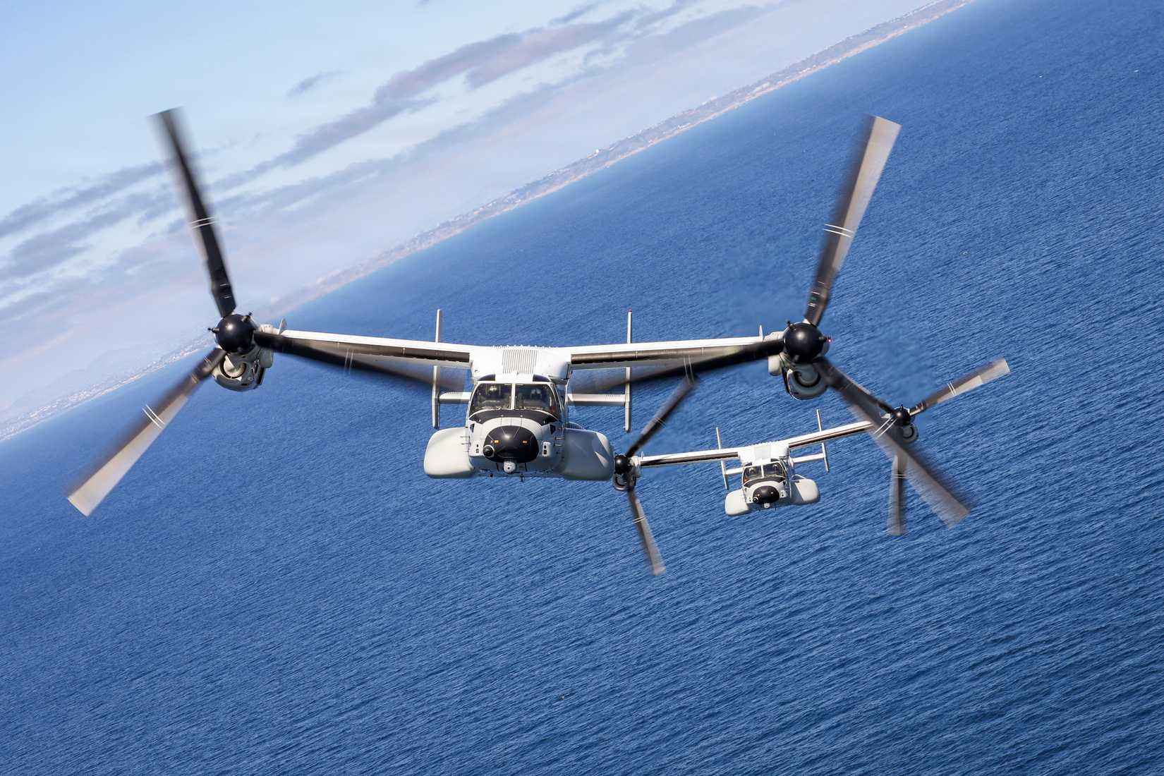 Two CMV-22B Osprey tiltroter aircraft of Fleet Logistics Multi-Mission Squadron (VRM) 50 fly over the Pacific Ocean enroute to conduct a flyover