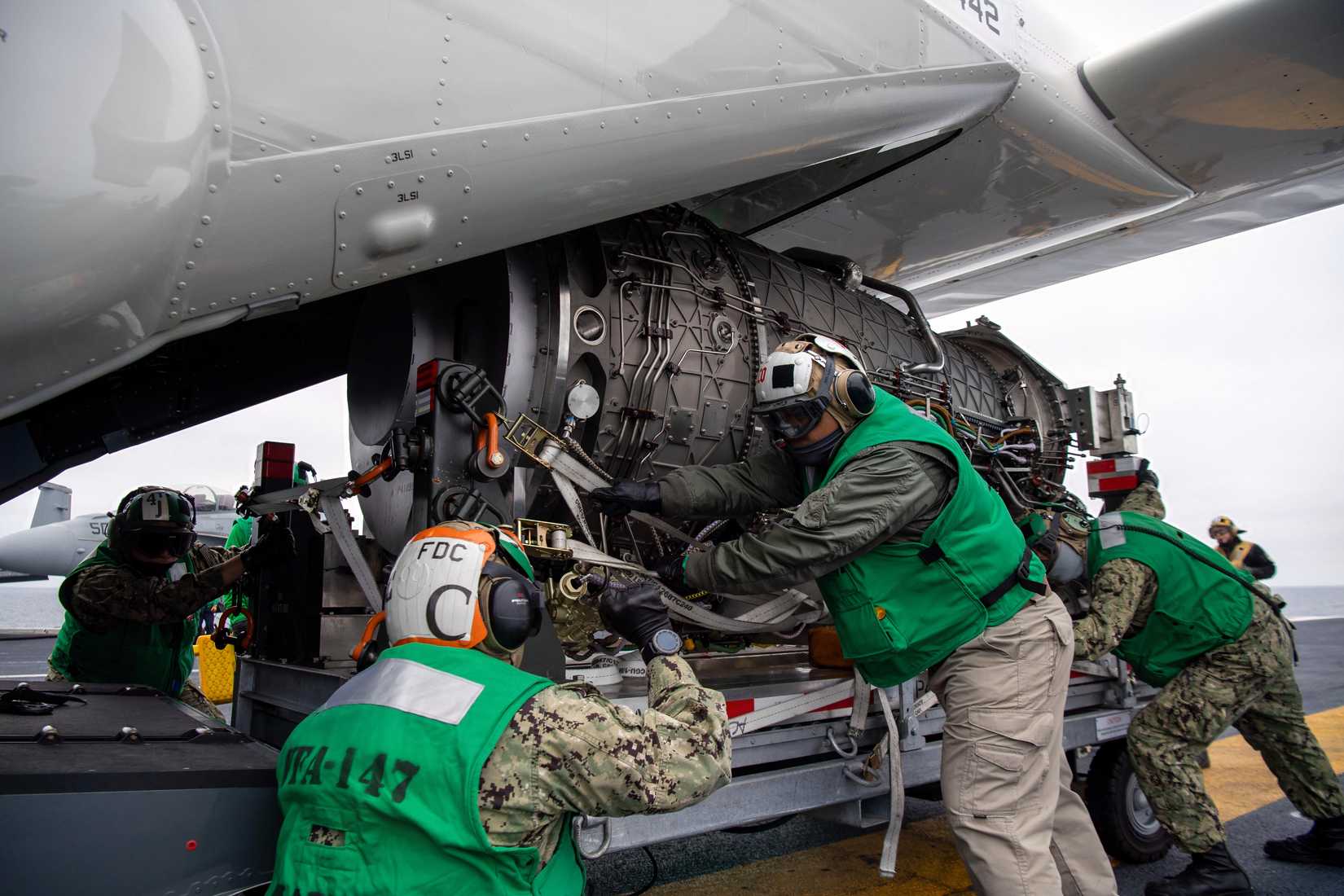 A photo of an F-35C engine being loaded onto an Osprey. 