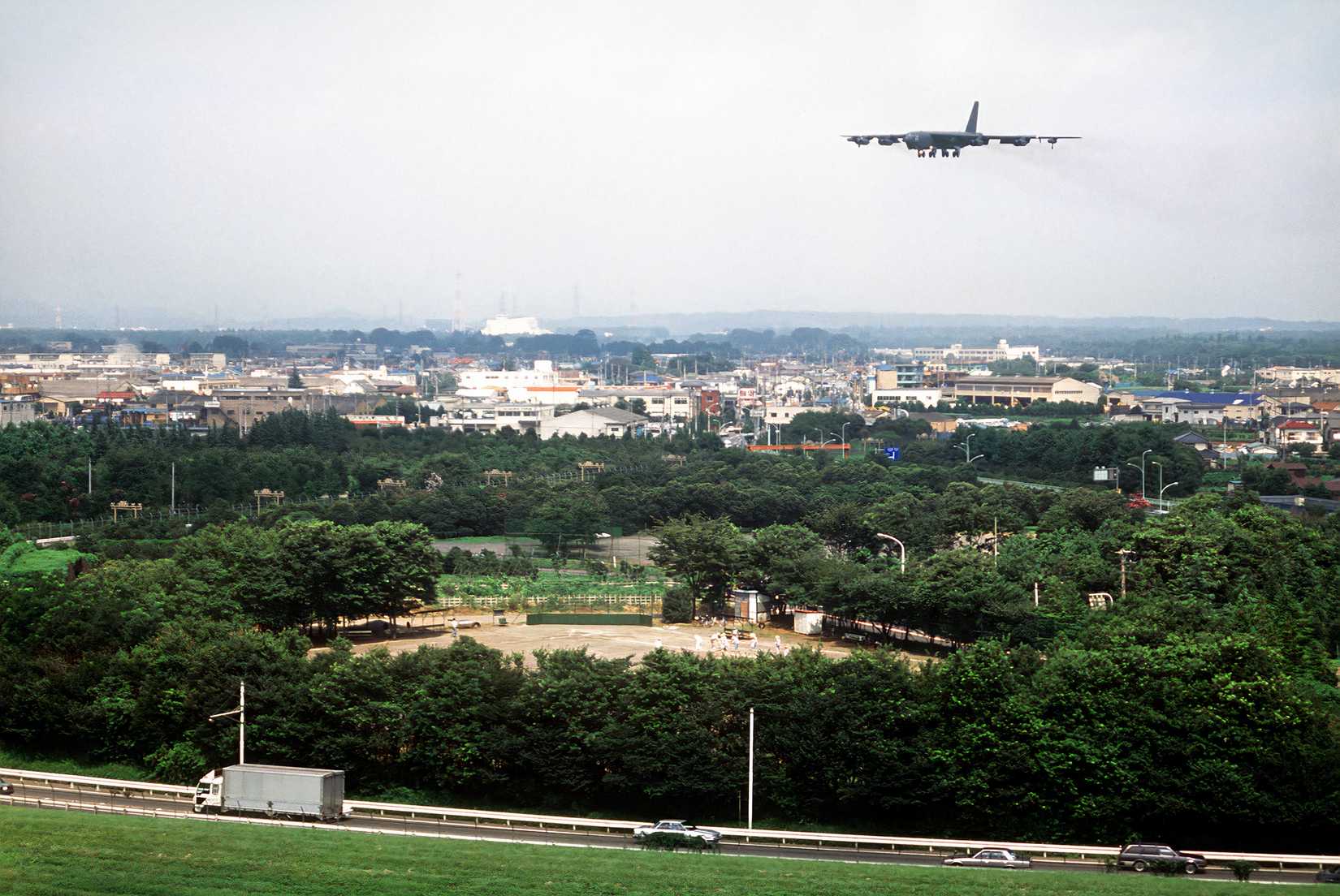 A photo of a B-52 flying over a city making an approach before landing
