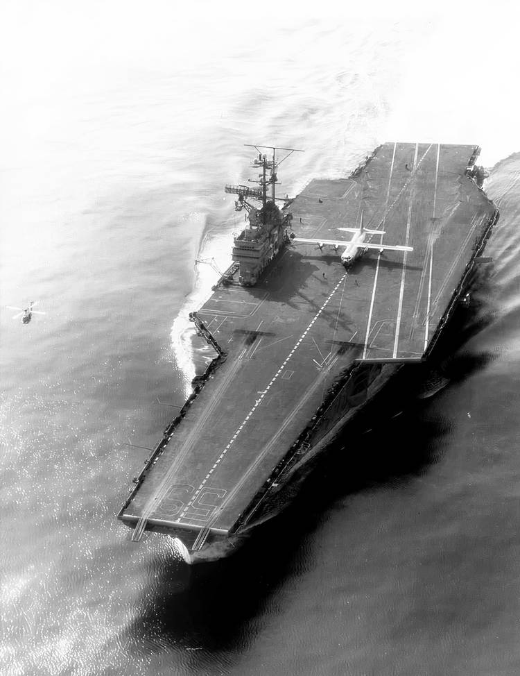 A black and white photo of a Marine Corps KC-130F on the deck of the USS Forrestal.
