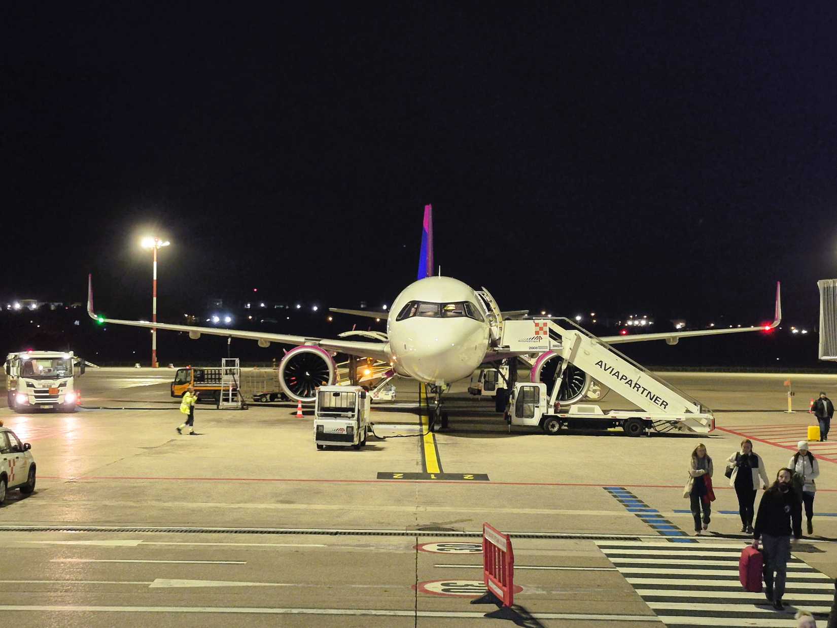 Wizz Air A321neo parked at an airport at night