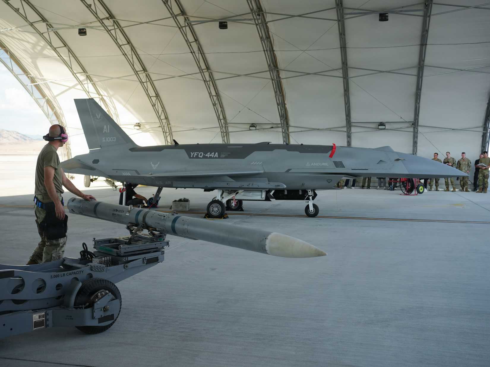 Airman assigned to the Collaborative Combat Aircraft Experimental Operations Unit prepares to load an inert missile onto a YFQ-44A Fury aircraft at Creech Air Force Base