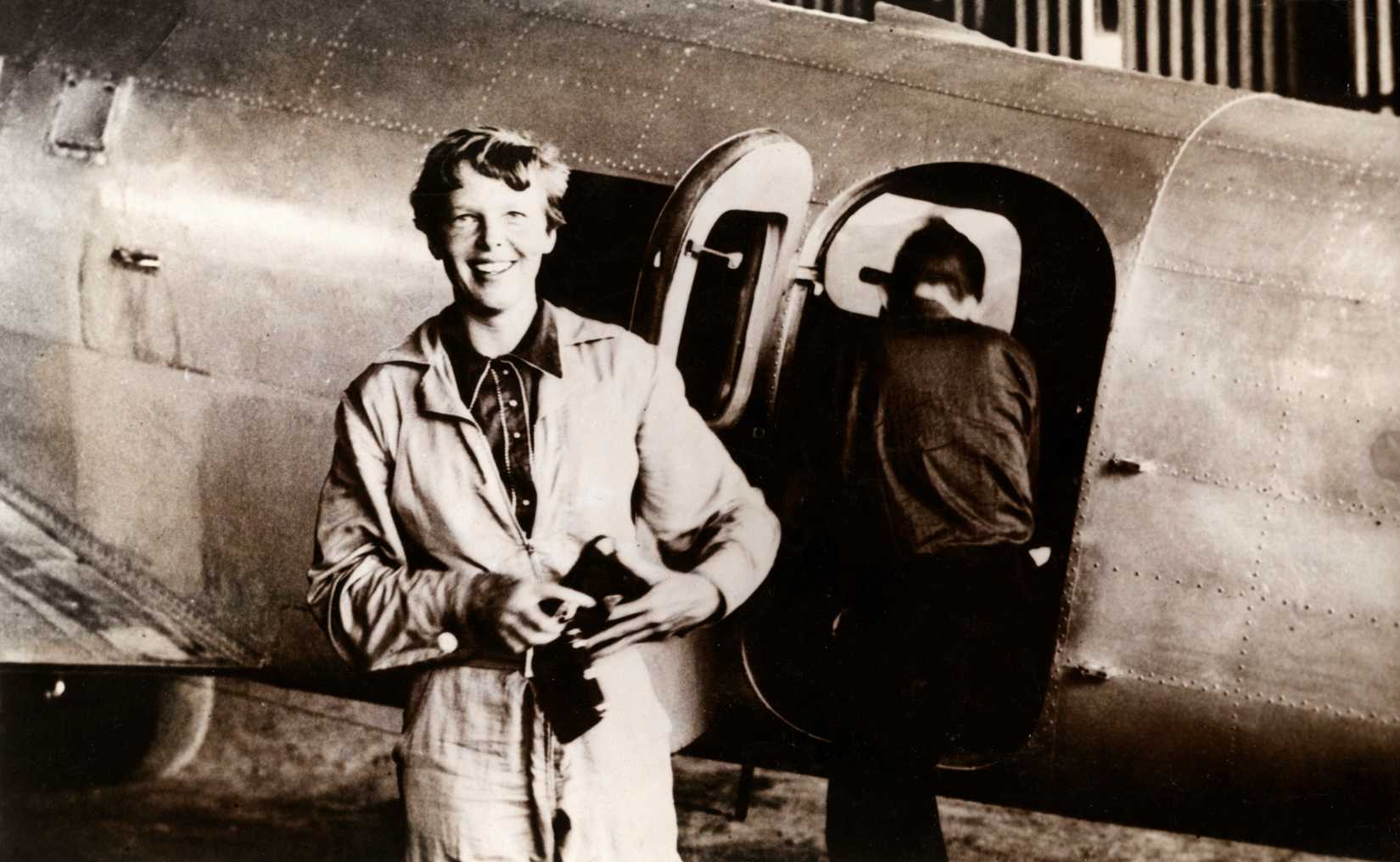 Amerikaanse_pilote,_vliegenier_Amelia_Earhart_(1897-1937)_in_vliegoverall_bij_een_vliegtuig,_SFA005001551