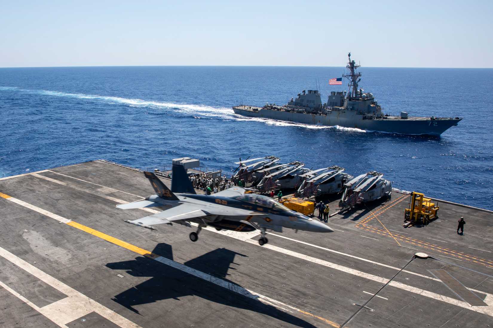 An FA-18F Super Hornet lands on USS Gerald R. Ford (CVN 78) alongside the Arleigh Burke-class guided-missile destroyer USS Mahan (DDG 72)
