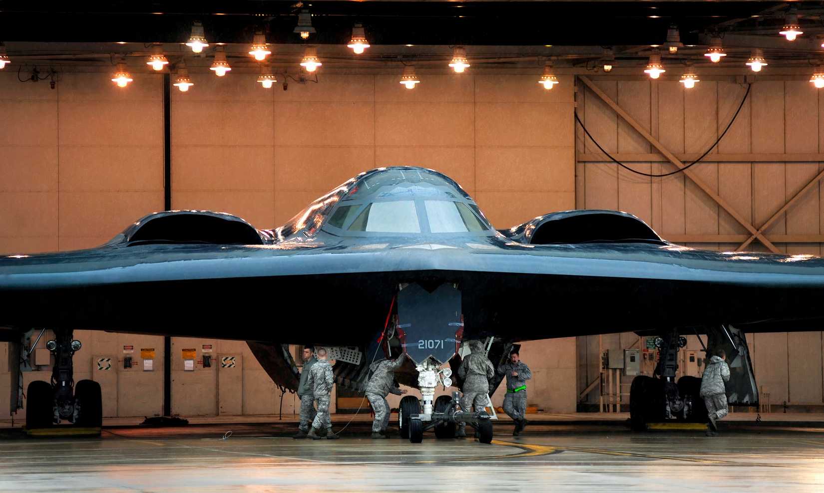A photo showing the B-2 bomber in a hangar being overlooked by technicians.