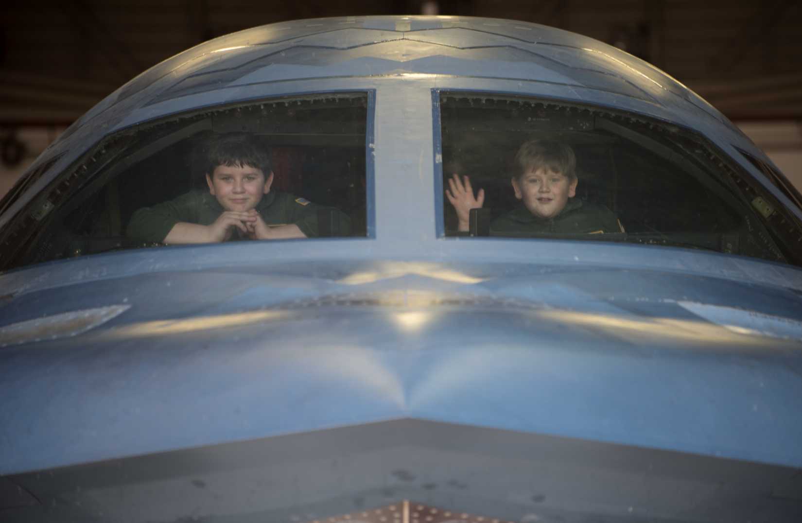 Brothers Ethan and Brian Rubio from Kansas City, Missouri stare out of the B-2 Spirit Stealth Bomber cockpit during their Pilot for a Day tour Dec. 19, 2018