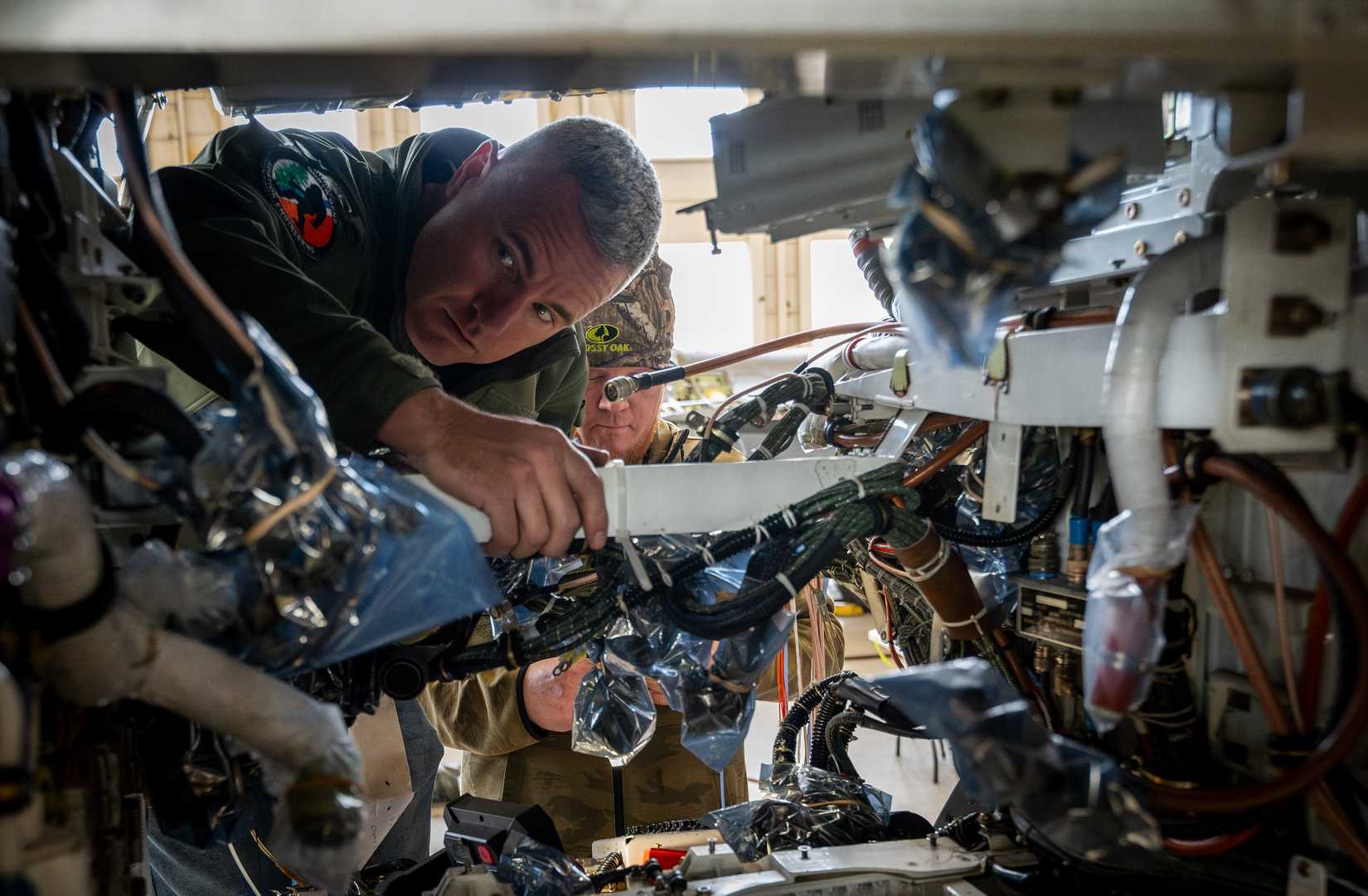 Chris Kiser, an aviation engineer, works on modifying an F-16 Fighting Falcon’s wiring as part of Viper Experimentation and Next-gen Operations Model