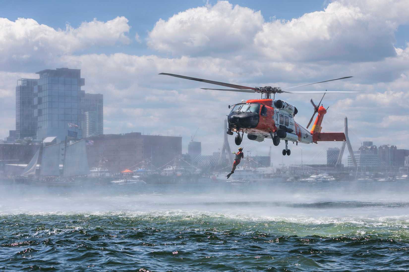 Coast Guard rescue swimmer deploys from an MH-60T Jayhawk helicopter during a search-and-rescue demonstration in Boston Harbor