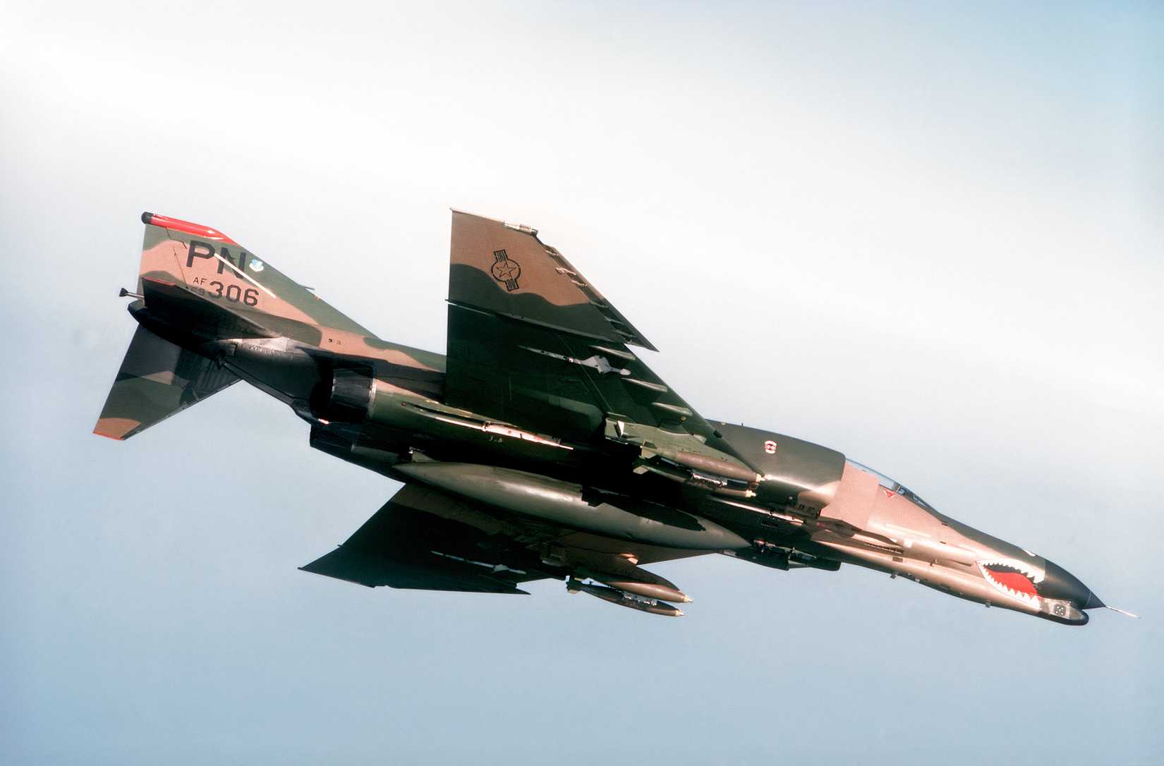 An F-4 Phantom II making a dive, the underside of the aircraft is slightly exposed revealing bombs