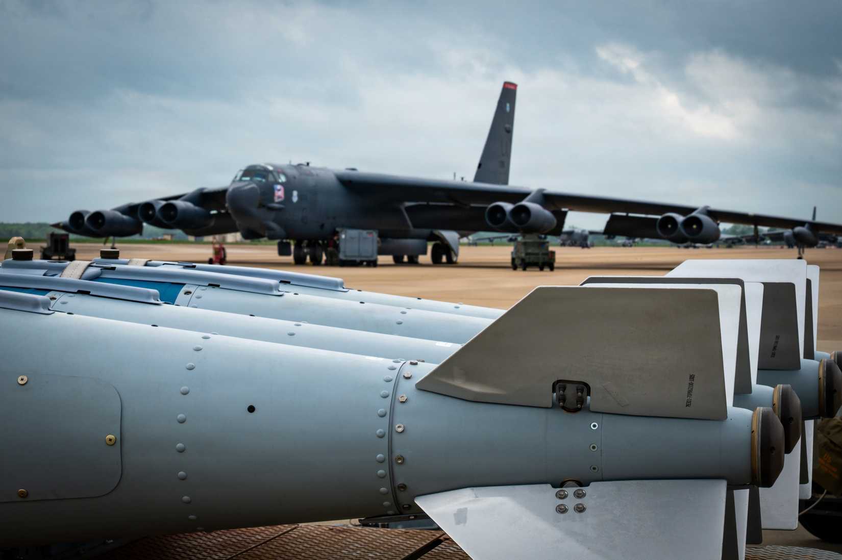 Guided bomb units sit in front of a B-52H Stratofortress aircraft prior to weapons loading during Gator Strike 26-2
