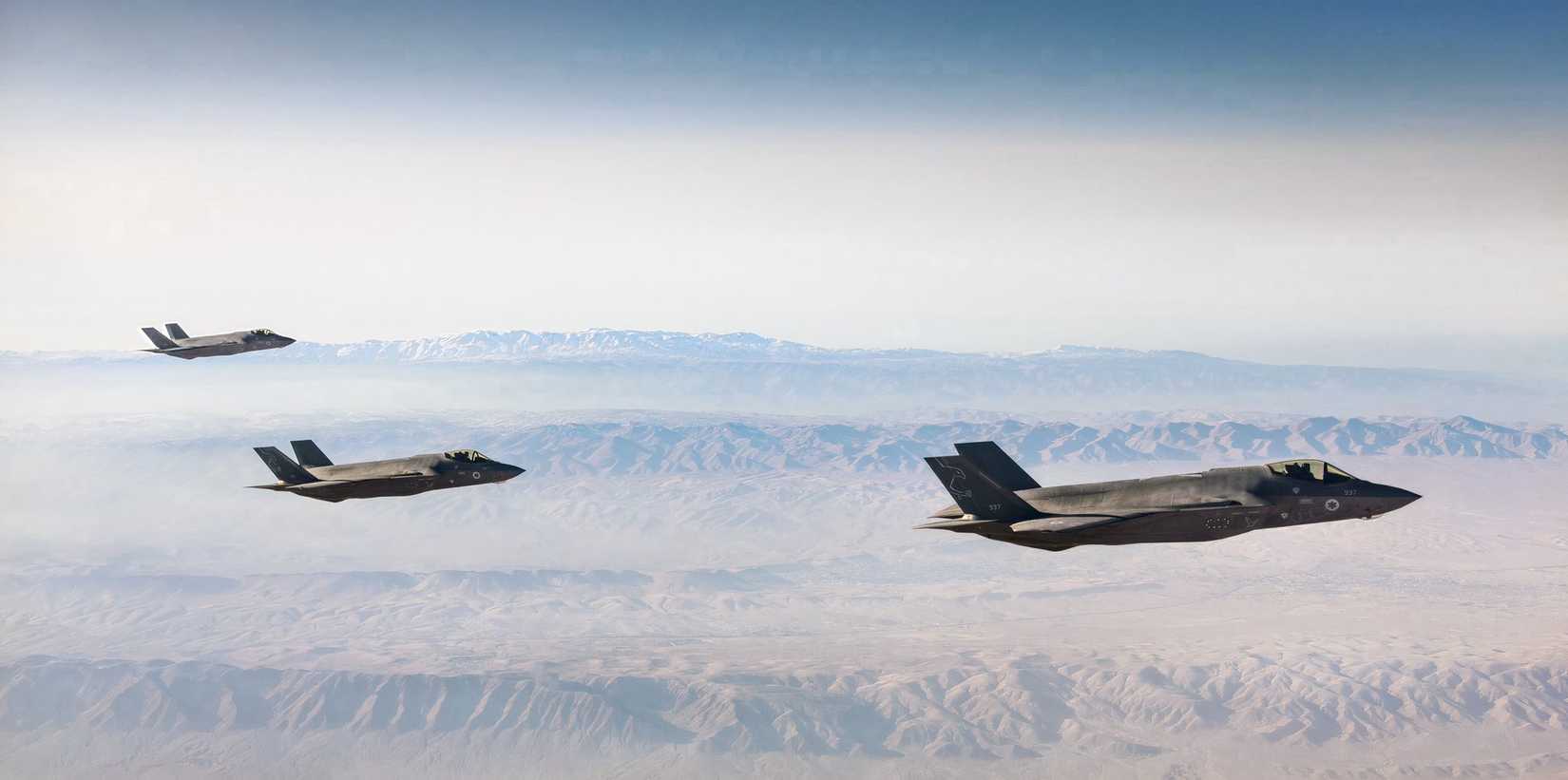 A photo of three IAF F-35s flying during Operation Roaring Lion, with mountains in the background. 