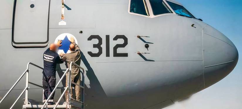 A close up image of the nose of Israel second KC-46 "Gideon". The photo shows, possibly, aircrew and a grond service member placing the Star of David decal on the nose of the aircraft.