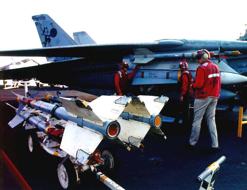 Navy aviation ordnancemen load Sidewinder and Phoenix missiles as they prepare an F-14 Tomcat for the first patrol of the extended no-fly zone over Iraq