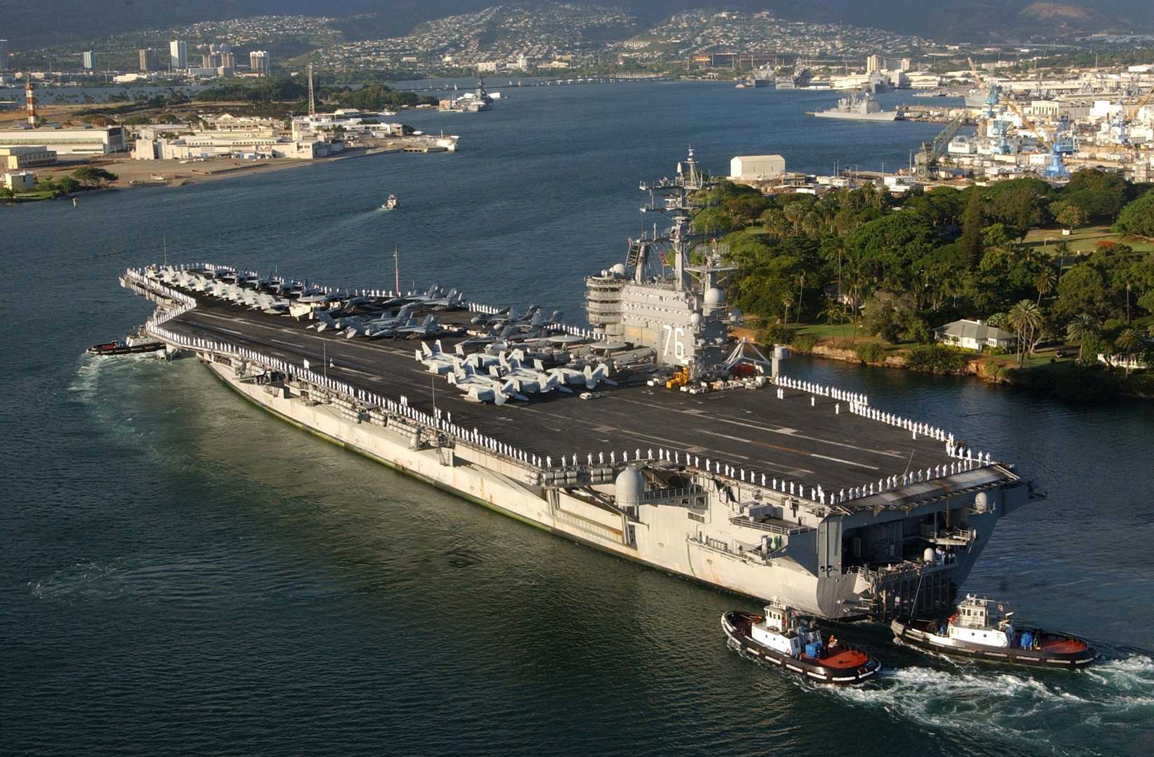 The aircraft carrier USS Ronald Reagan (CVN 76) is aided by harbor tugs as it enters Pearl Harbor, Hawaii