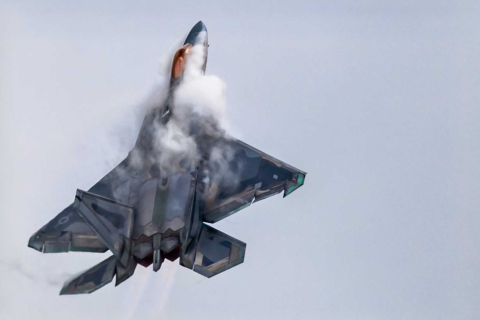 A photo of an F-22 in a vertical climb.