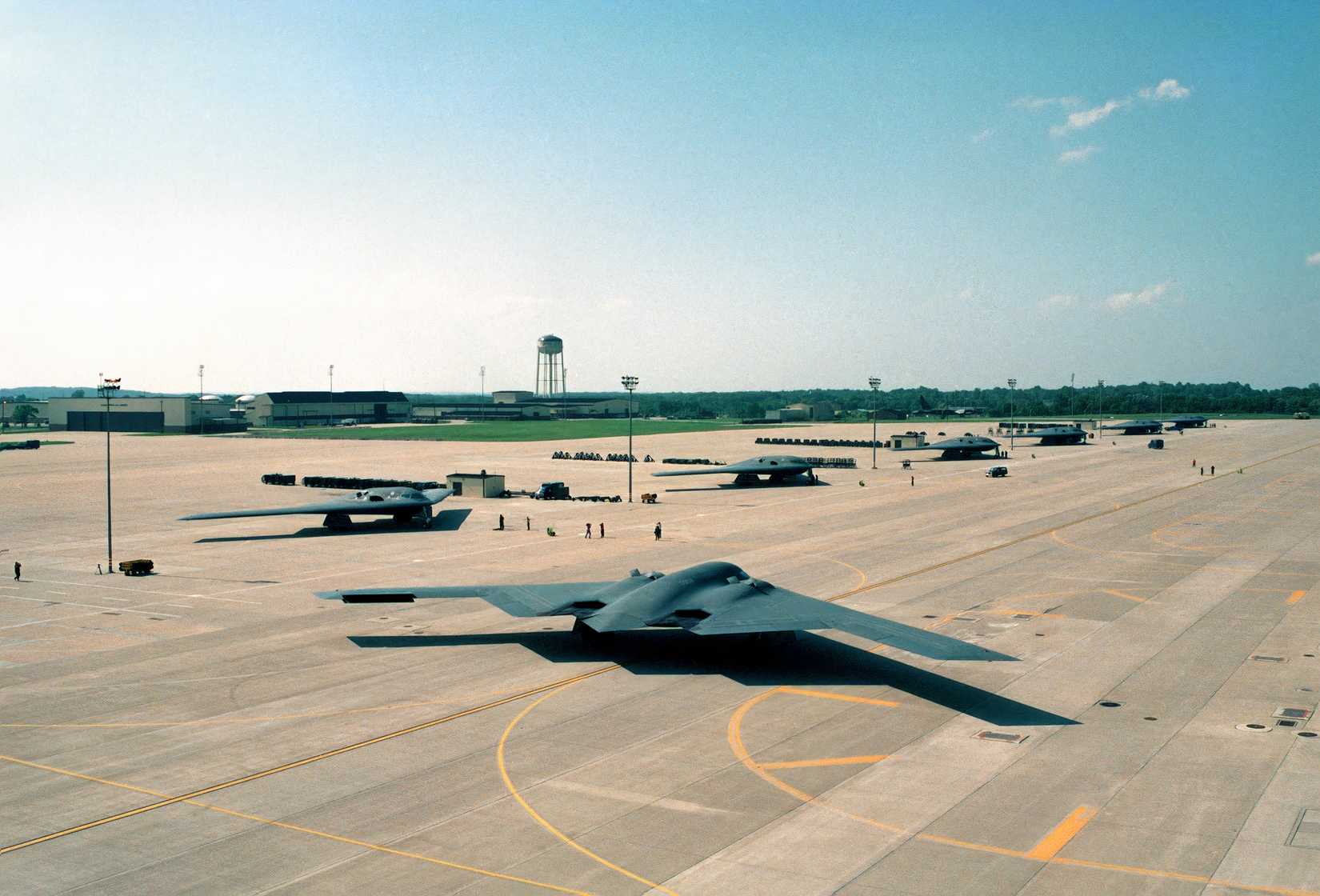 A photo showing a B-2 readying to takeoff with other B-2s parked on the side.