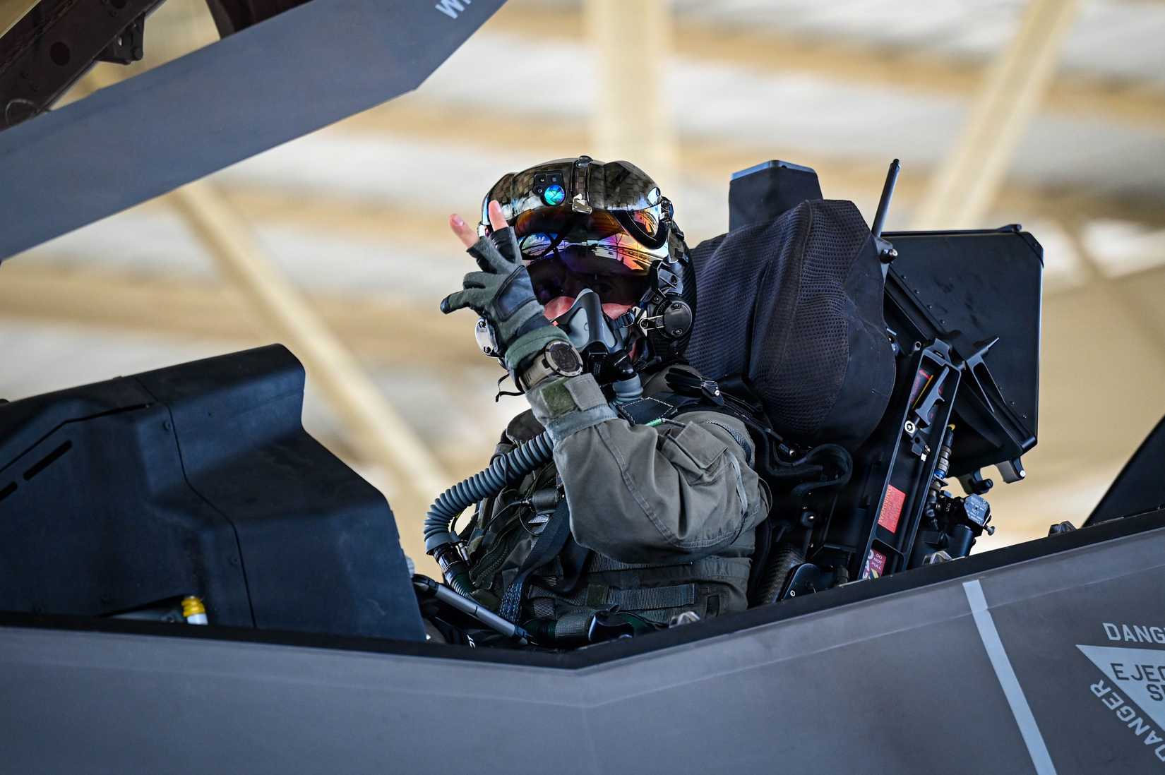 A Belgian Air Force pilot assigned to the 312th Fighter Squadron signals from the cockpit of an F-35A Lightning II