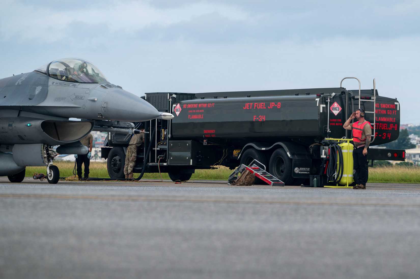 A crew chief assigned to the 77th Expeditionary Fighter Generation Squadron salutes the pilot of an F-16 Fighting Falcon