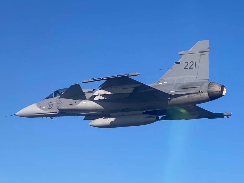 A Swedish Air Force JAS 39 Gripen, flies alongside an FA-18F Super Hornet