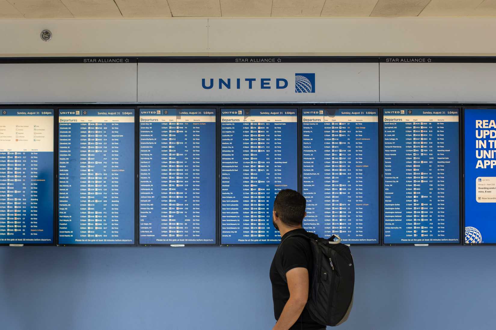 A traveler checks the departures boards for United Airlines flights at the boarding area in Chicago O'Hare International Airpor