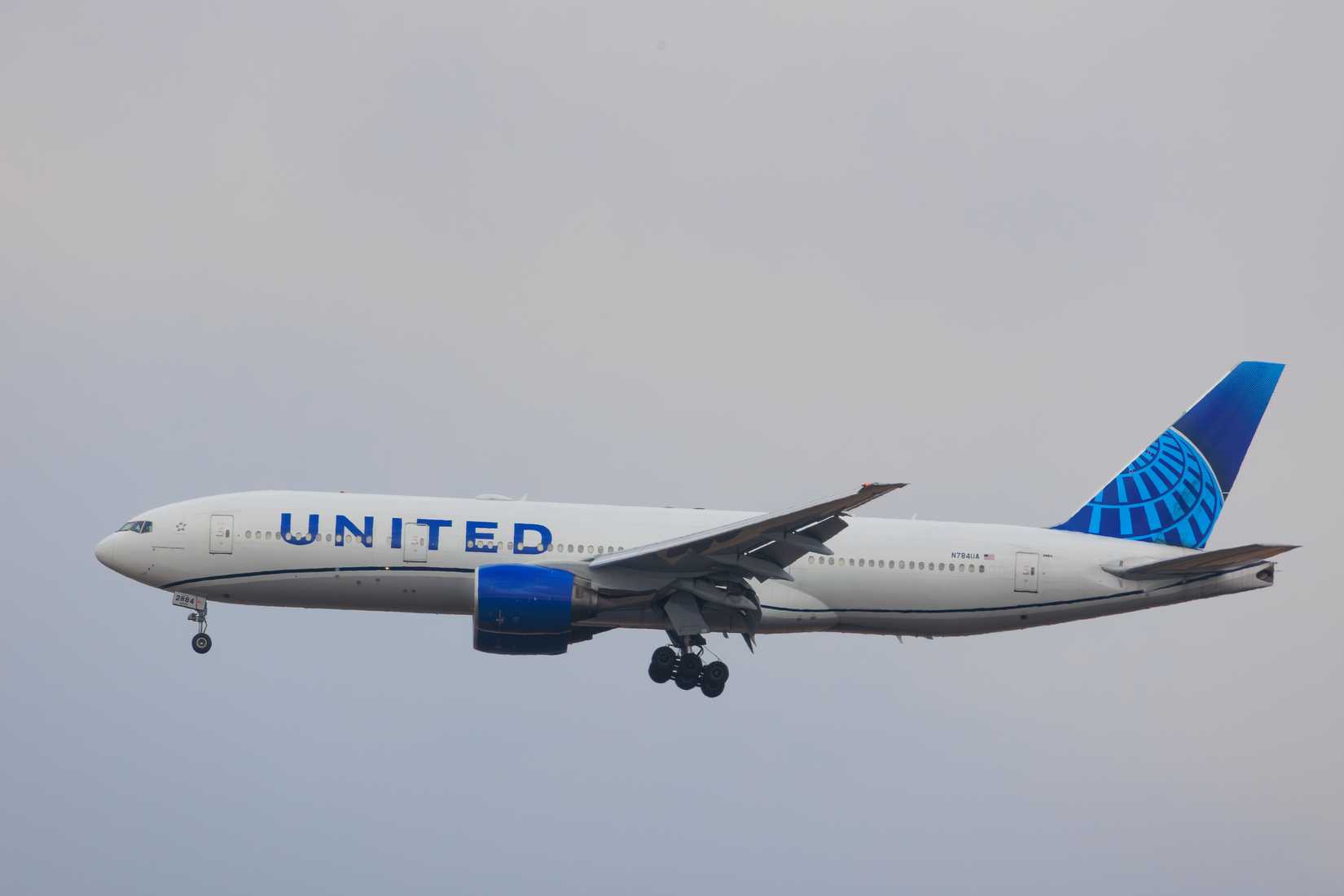 A United Airlines Boeing 777 aircraft (N794UA) with landing gear down approaches Narita International Airport