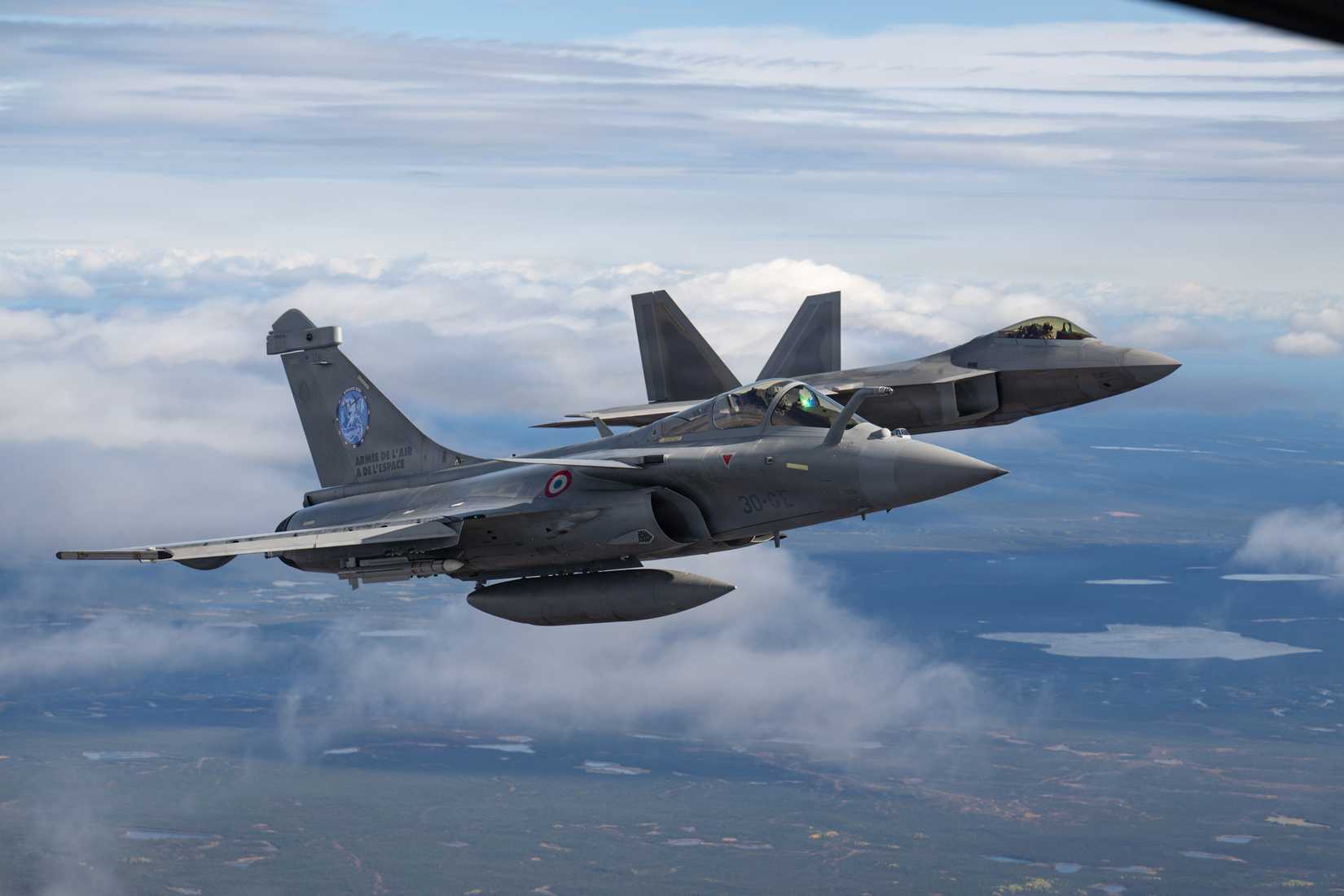 Air Force F-22A Raptor assigned to the 3rd Air Expeditionary Wing, back, and a French Air and Space Force Dassault Rafale F4