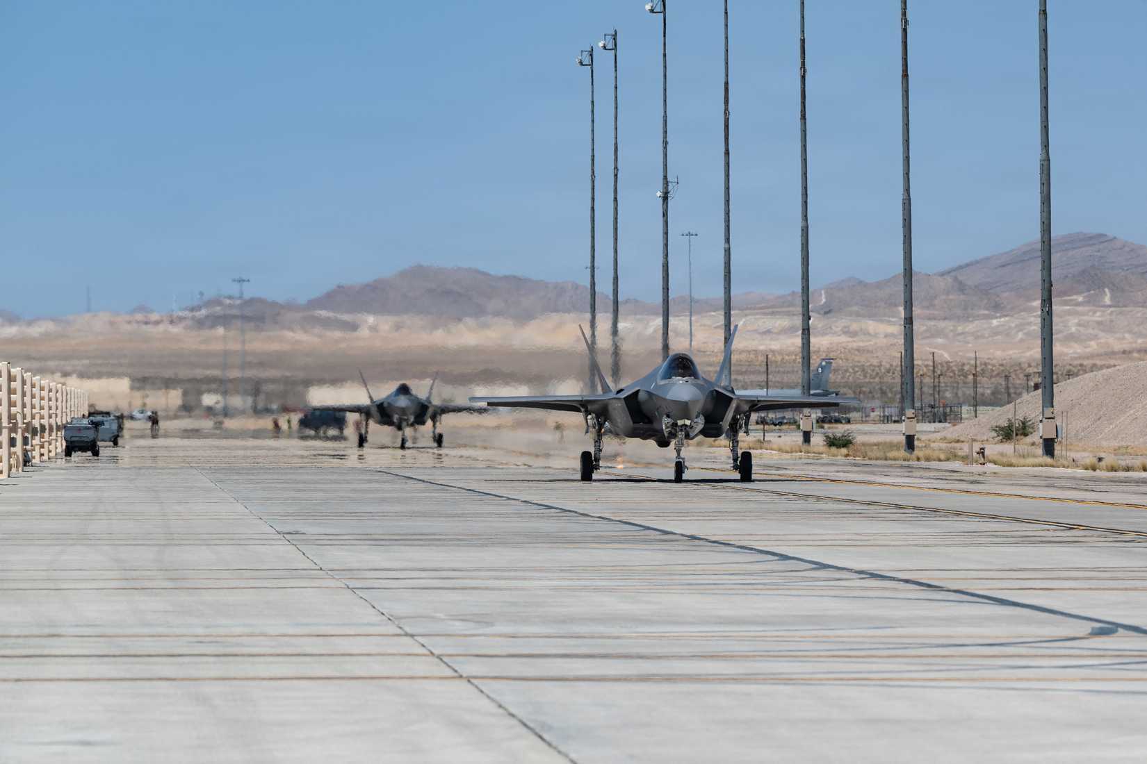 Air Force F-35A Lightning II aircraft assigned to the 6th Weapons Squadron taxi toward the hot-pit refueling area during Exercise Rogue Wave at Nellis