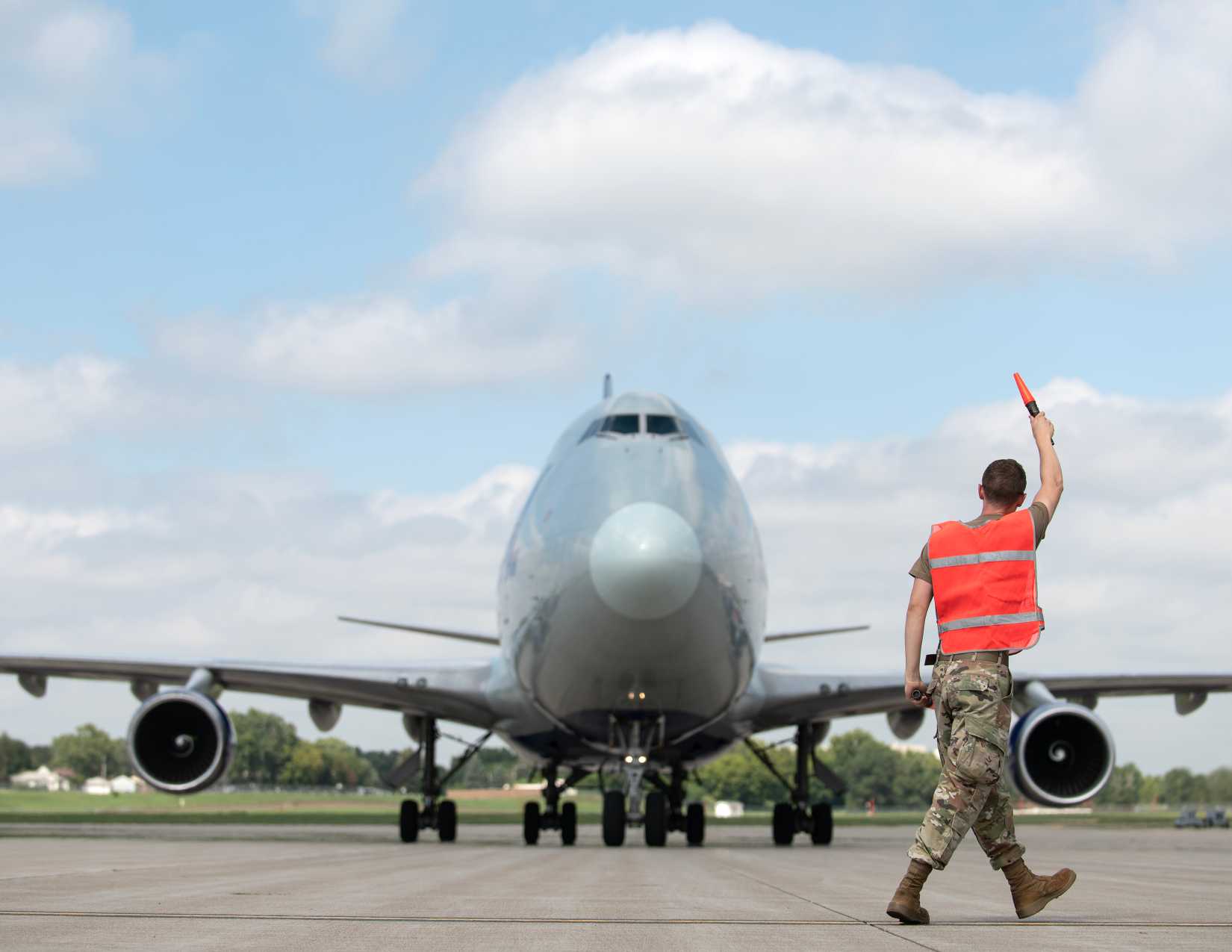  Air Force Senior Airman Josh Eckelberry, 133rd Aircraft Maintenance Squadron, marshals in a Boeing 747 transport aircraft