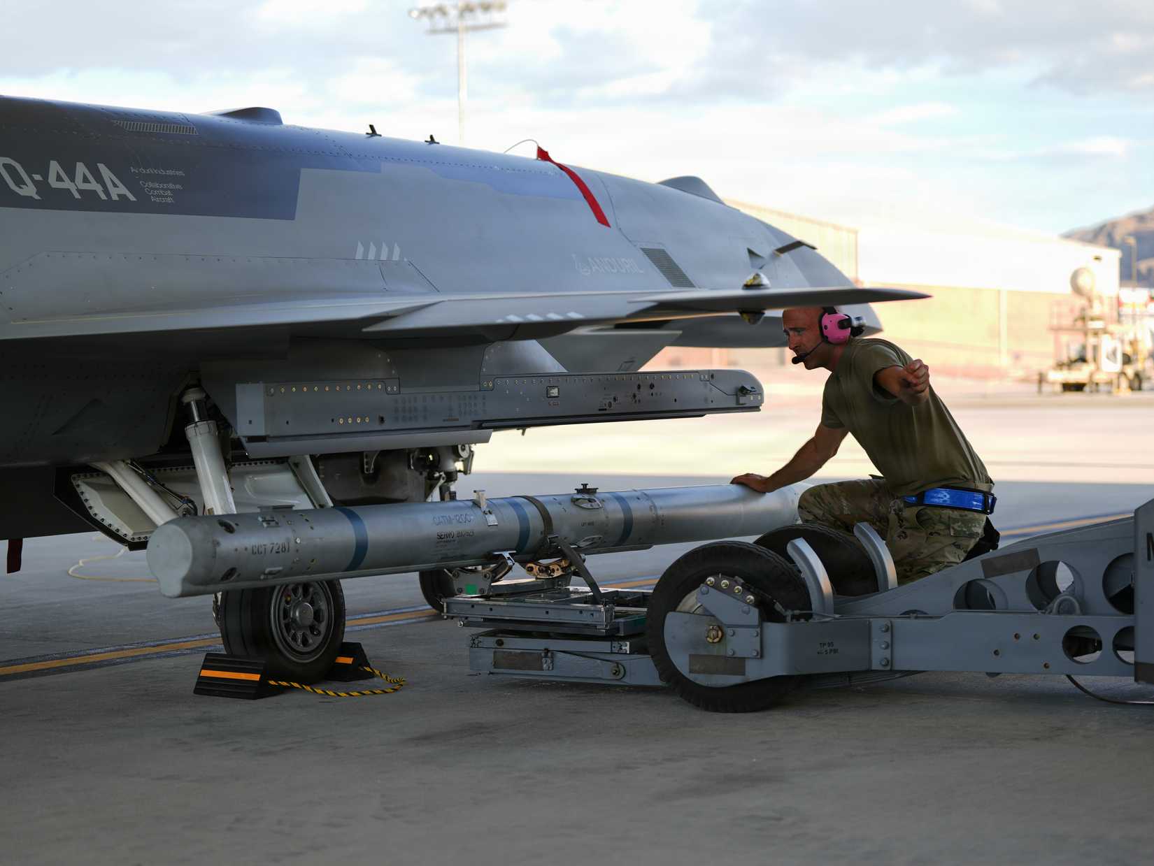 Airman assigned to the Collaborative Combat Aircraft Experimental Operations Unit loads an inert missile onto a YFQ-44A Fury aircraft at Creech Air Force Base