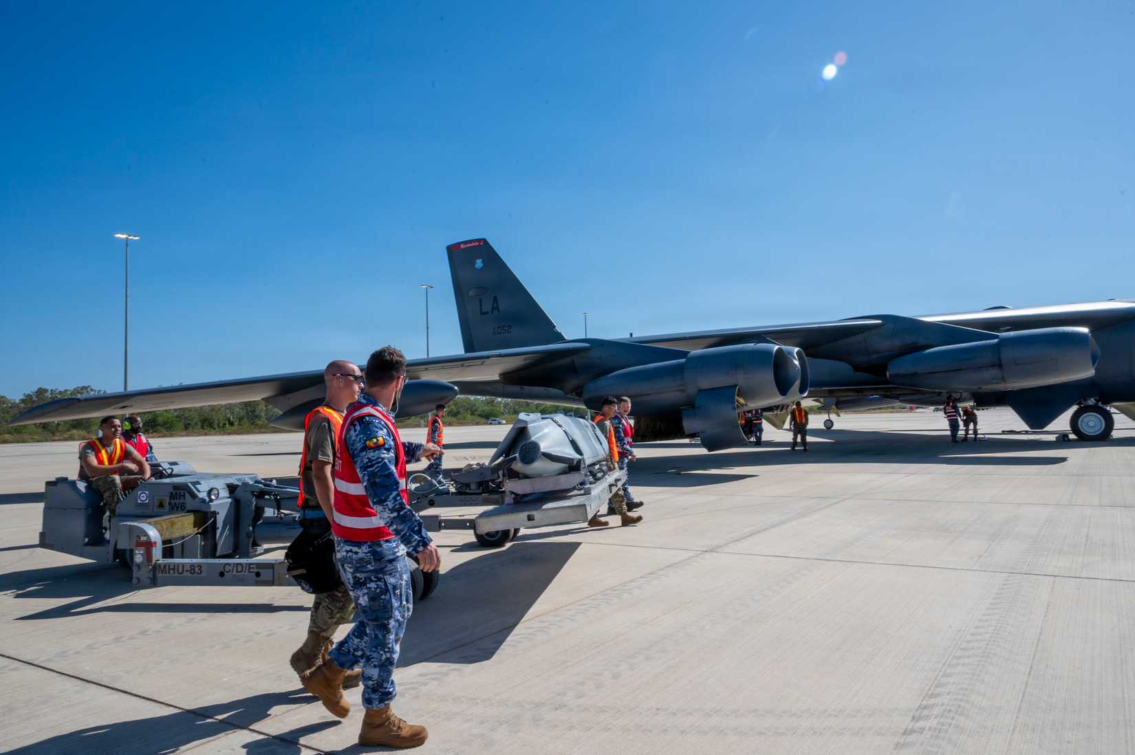 Airmen and members of the Royal Australian Air Force deliver inert munitions to a B-52H Stratofortress