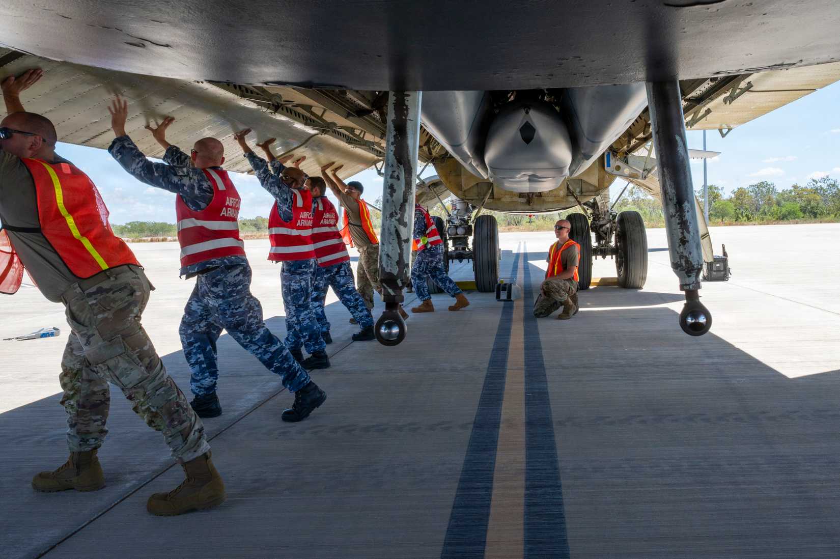 Airmen and members of the Royal Australian Air Force lower a B-52H Stratofortress bomb bay door