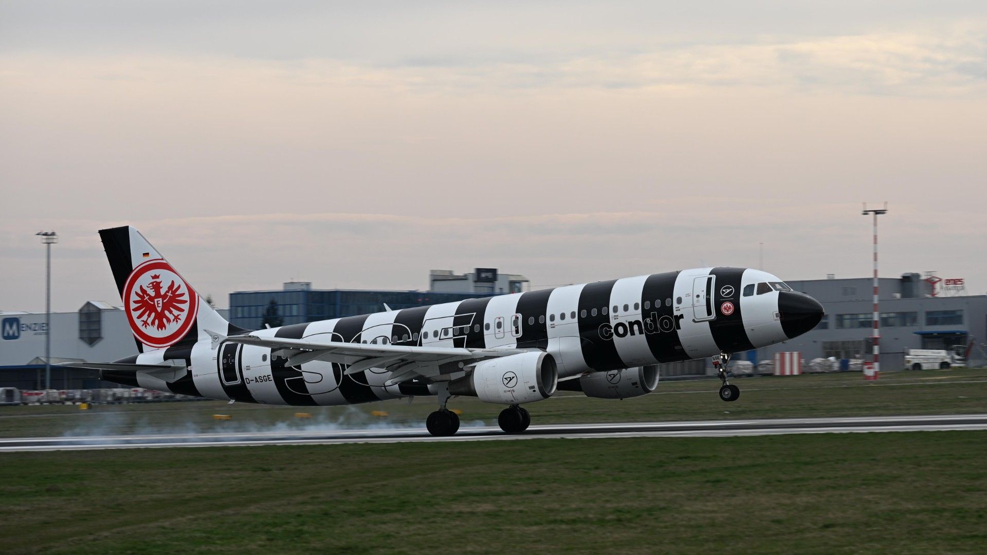 Condor Airbus A320-214 (D-ASGE, Eintracht Frankfurt Livery) landing with visible tire smoke